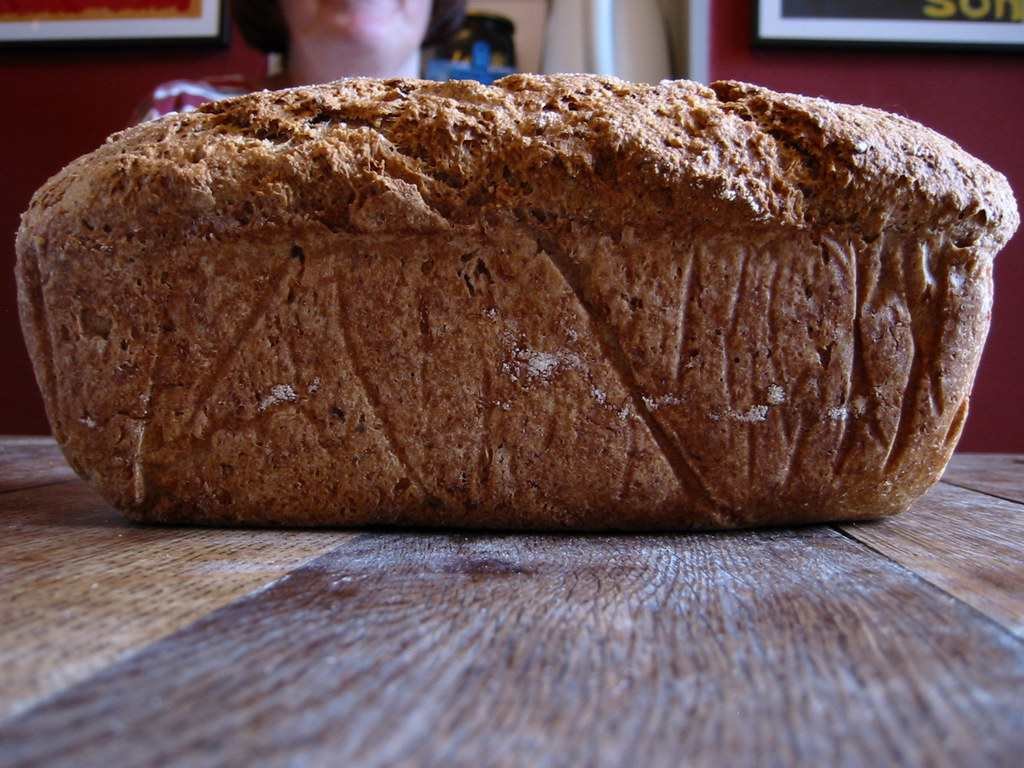 Freshly baked homemade bread loaf on a cutting board, a fundamental skill taught in an online baking course